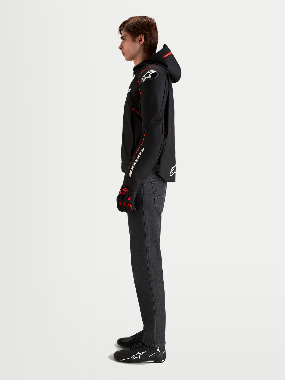 Alpinestars Zaca V2 Waterproof Jacka, vattentät motorcykeljacka för herr i svart och rött, med integrerad huva och förböjda ärmar, visad av en modell i profil