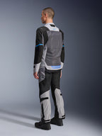 Manlig modell sedd bakifrån bär Alpinestars ST-2 Air Jacket i Ice Gray, Dark Gray och Black, med en stor grå mesh-ryggpanel, blå logotypdetaljer och matchande motorcykelbyxor för sommartouring.
