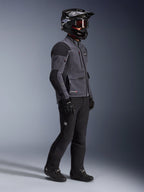 Motorcykelförare i Alpinestars Maxdura Drystar®XF Laminated Armored Shell-jacka i Deep Gray och svart, kombinerad med svarta adventure-byxor, svart hjälm med goggles, svarta handskar och stövlar, studiobild i helfigur som framhäver den tekniska dual-sport-utrustningen.