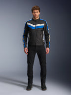 Alpinestars T-Dyno WR-jacka, textiljacka för motorcykel, svart, blå och ecru, bärs av en manlig modell med svarta byxor och stövlar, med chevron-ränder på bröstet och klassisk bikerdesign