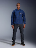 Alpinestars Revved WR Jacket, marinblå, motorcykeljacka i coach-stil, bärs av en man med mörka denimjeans och svarta sneakers, med tryckknappsstängning och 3D Alpinestars-logotyp, urban samtida streetwear
