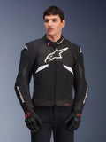 Alpinestars T-GP R V3 Drystar Jacket, Waterproof Sport Textile Jacket, Black and White with Red accents, featuring a large white star logo on the chest and white branding on the sleeves, worn with black and red motorcycle gloves