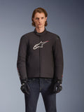 Alpinestars SMX Waterproof Jacket, Black textile motorcycle jacket with white and red star logo on the chest, worn by a model with black gloves and blue jeans, featuring external shoulder sliders and a sporty fit.
