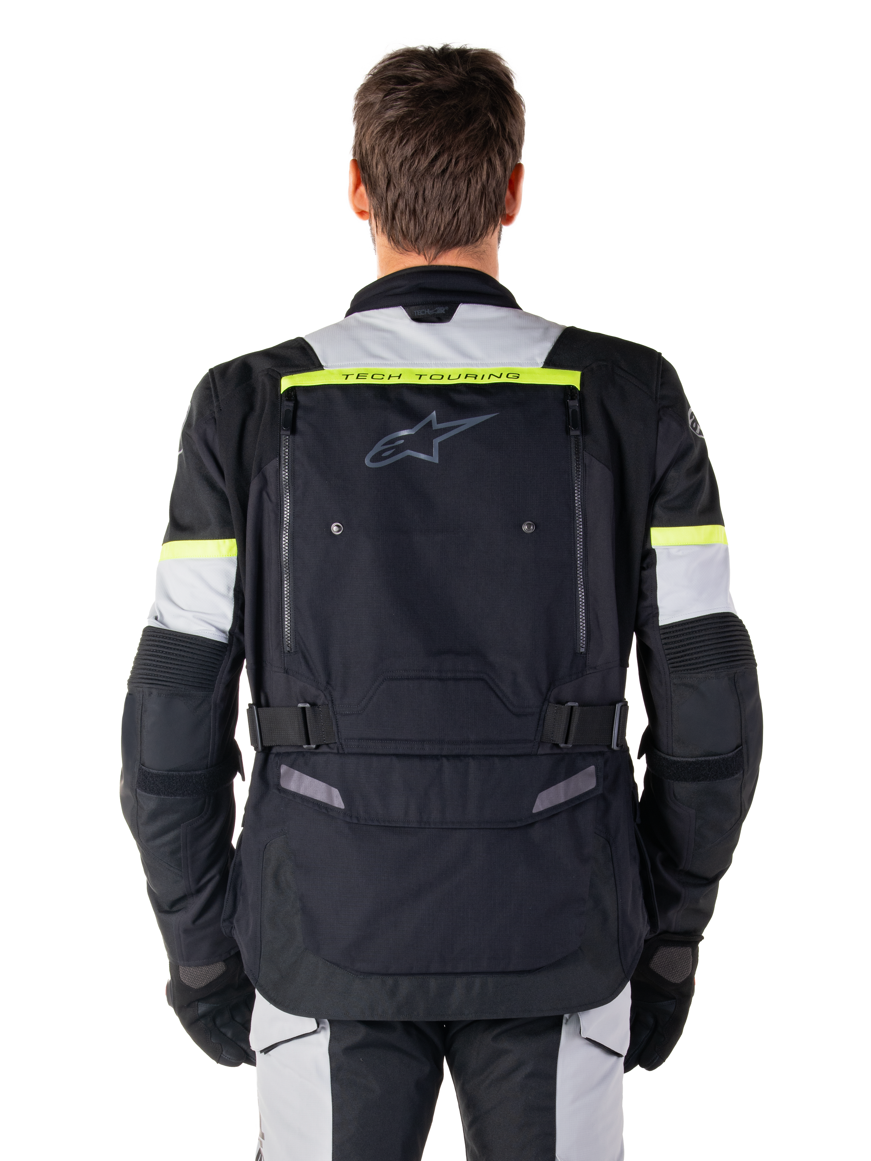 Alpinestars Bogota' Pro Drystar®-jacka, motorcykeljacka för adventure touring, svart, isgrå och fluorescerande gul, vy bakifrån som visar 'TECH TOURING'-märkning på en fluorescerande gul rand, stor ventilationspanel på ryggen och justerbara midjeremmar, teknisk allvädersutrustning