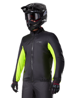 Alpinestars Bogotá Pro Drystar® vattentätt foder, svart med neongula detaljer på ärmarna, bärs av en förare med svart hjälm och goggles, teknisk motorcykelutrustning