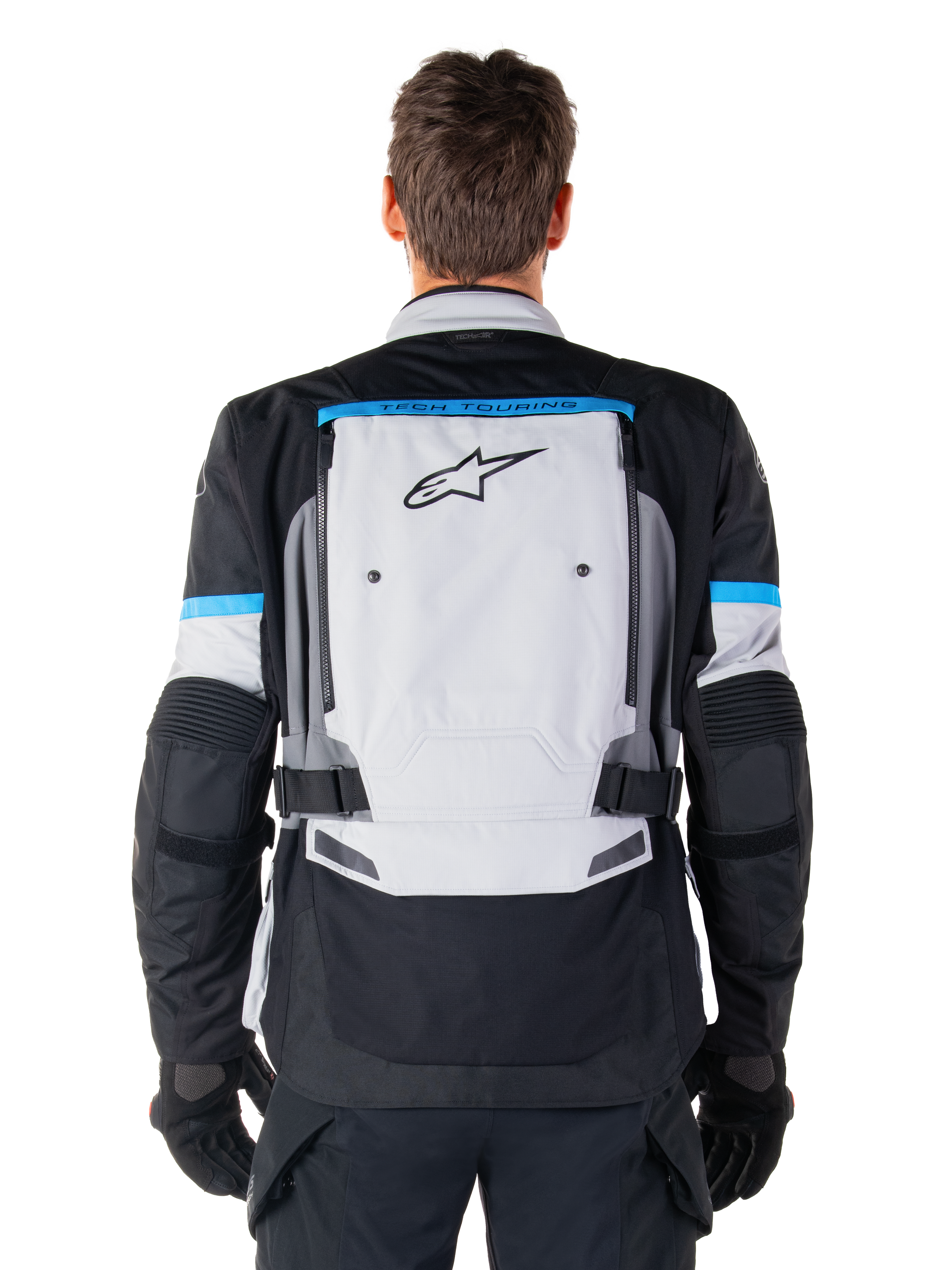 Alpinestars Bogota' Pro Drystar® jacka, äventyrsmotorcykeljacka, Ice Gray, svart och cyan, vy bakifrån med en stor ljusgrå panel med svart stjärnlogotyp, cyanfärgade detaljer med Tech Touring-branding och justerbara midjeremmar