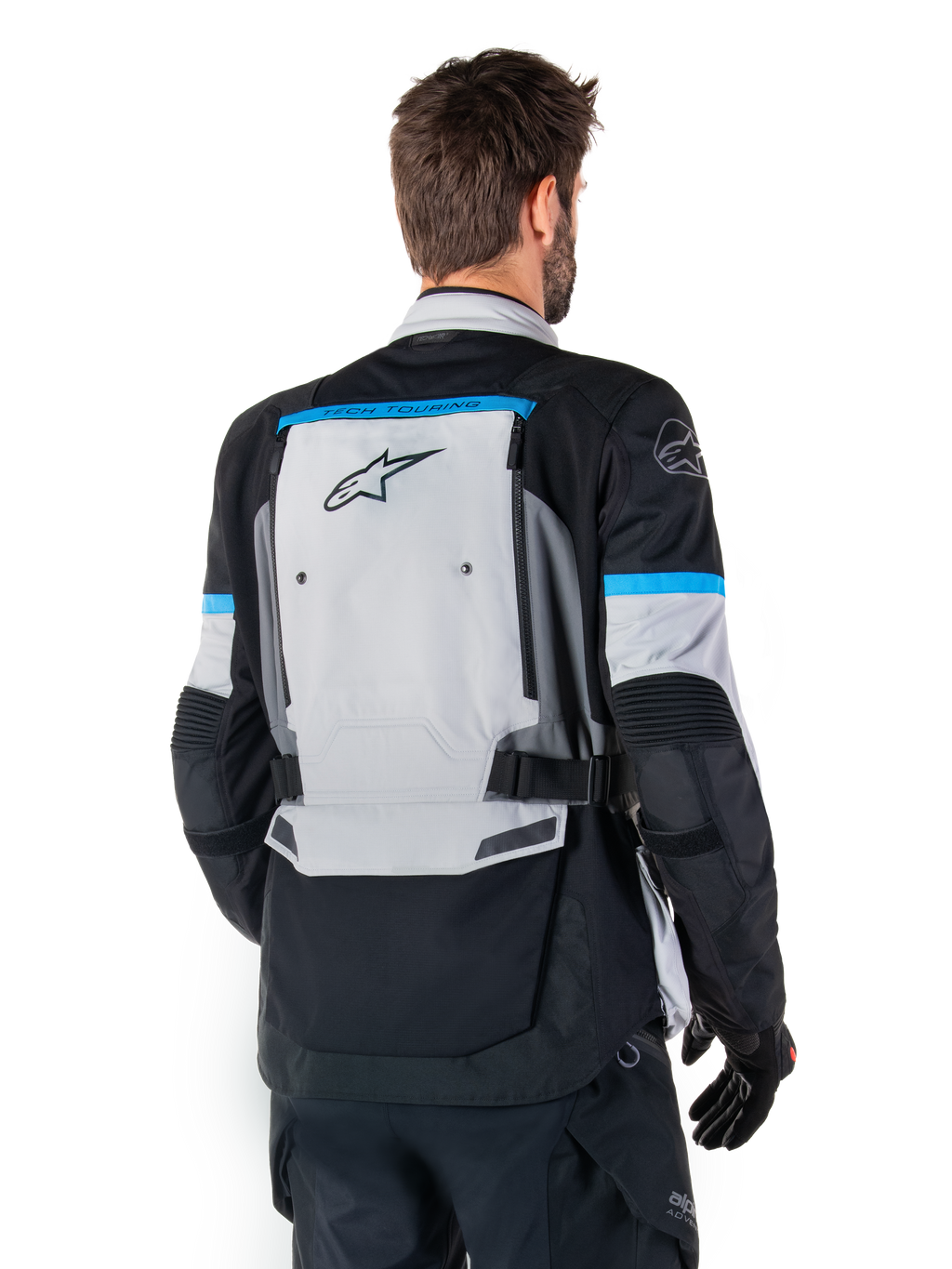Alpinestars Bogota' Pro Drystar®-jacka, äventyrsmotorcykeljacka, Ice Gray, svart och cyan, ryggvy som framhäver den stora grå ryggpanelen med Tech Touring-branding, cyanfärgade detaljer på ärmarna och slitstark textilkonstruktion.
