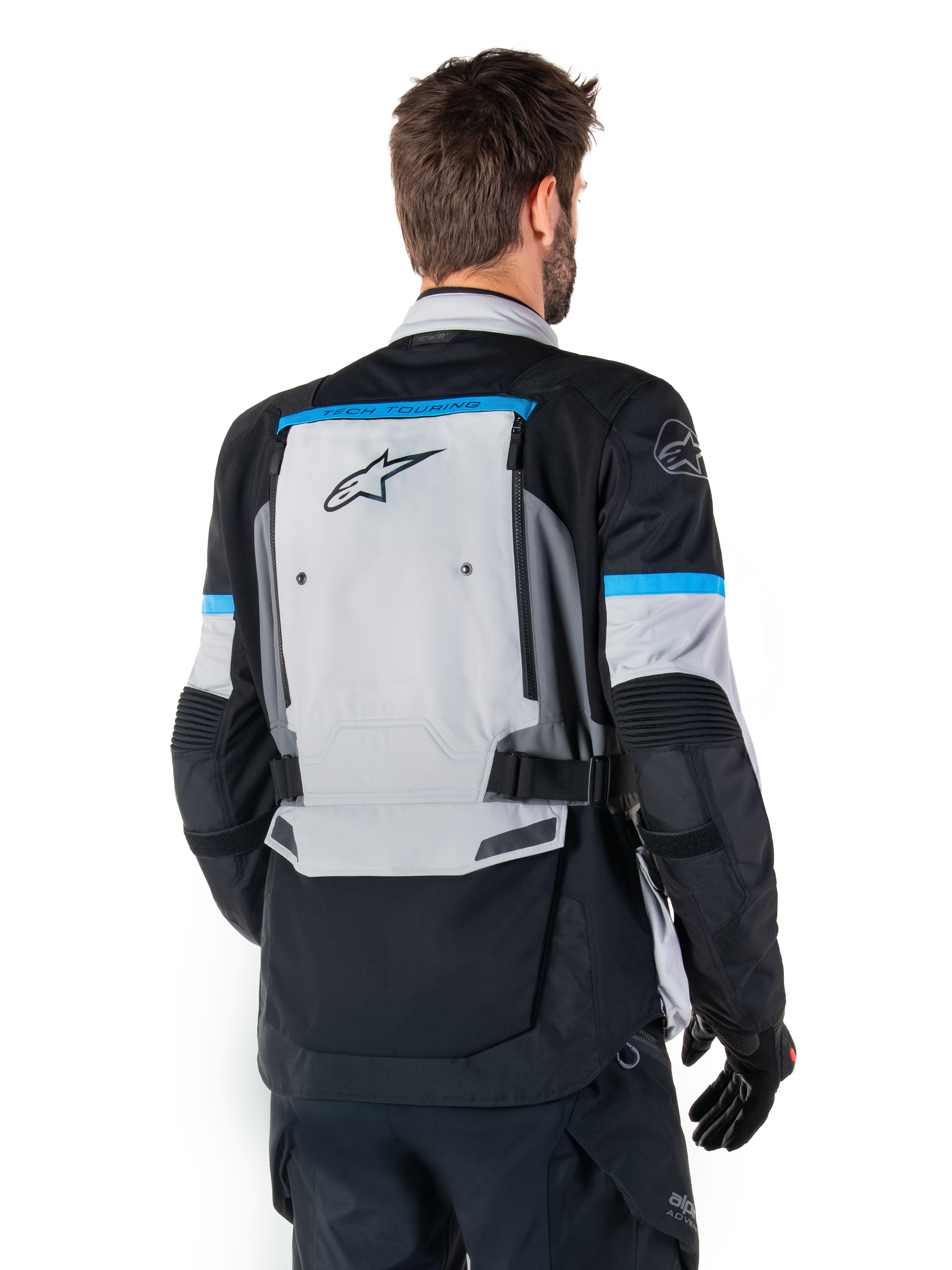 Alpinestars Bogota' Pro Drystar®-jacka, äventyrsmotorcykeljacka, Ice Gray, svart och cyan, ryggvy som framhäver den stora grå ryggpanelen med Tech Touring-branding, cyanfärgade detaljer på ärmarna och slitstark textilkonstruktion.