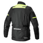 Alpinestars Andes V3 Drystar®-jacka, vy bakifrån av äventyrsmotorcykeljacka i svart och gul fluo, med en stor verktygsficka i nedre delen av ryggen med Alpinestars-logotyp, axelpaneler med hög synlighet och justerbara midjeremmar.