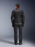 Rear view of a rider wearing the Alpinestars Andes Air Drystar® Jacket in Black, featuring extensive mesh ventilation panels on the back, red Alpinestars logo, and reflective accents, paired with matching motorcycle pants and gloves for adventure touring.