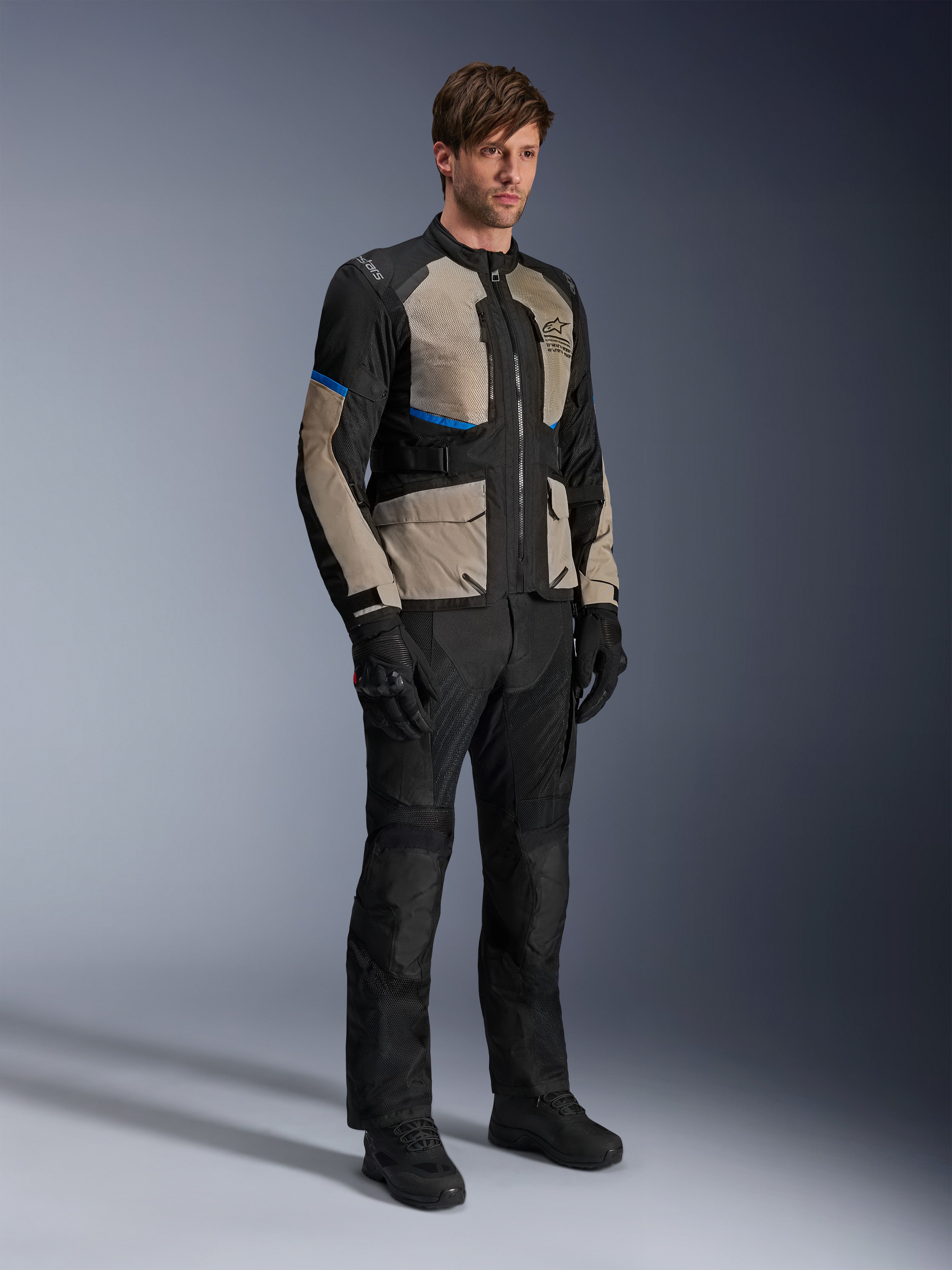 Alpinestars Andes Air Drystar® Jacket, Motorcycle Touring Jacket, Black Laurel Gray and Bright Blue, worn with matching riding pants and gloves, featuring extensive mesh panels for airflow and a road-oriented fit, adventure touring gear