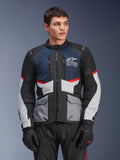 Alpinestars Andes Air Drystar®-jacka, motorcykeltouringjacka, djupblå, svart och isgrå med röda detaljer, bärs av en manlig modell med svarta handskar, med ventilationspaneler i mesh och praktiska framfickor, modern utrustning för äventyrs- och vägkörning