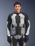 Manlig förare som bär Alpinestars Andes Air Drystar®-jacka i Ice Gray, Dark Gray och svart, med neongula detaljer och ventilationspaneler i mesh, stylad med matchande motorcykelbyxor och handskar, adventure touring-utrustning