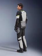 Alpinestars Andes Air Drystar® jacka, touringjacka för motorcykel, isgrå och mörkgrå med svarta paneler och neongula accenter, bärs med matchande byxor och handskar, trekvartsvy bakifrån som visar meshventilation och Alpinestars-logotyp.