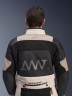 Vy bakifrån av Alpinestars AMT-10LAB Drystar® XF-jacka i färgerna White Sand och svart, med en stor AMT-logotyp på ryggpanelen i mesh, Alpinestars-branding på nedre delen av ryggen och teknisk textilkonstruktion för äventyrsmotorcykling