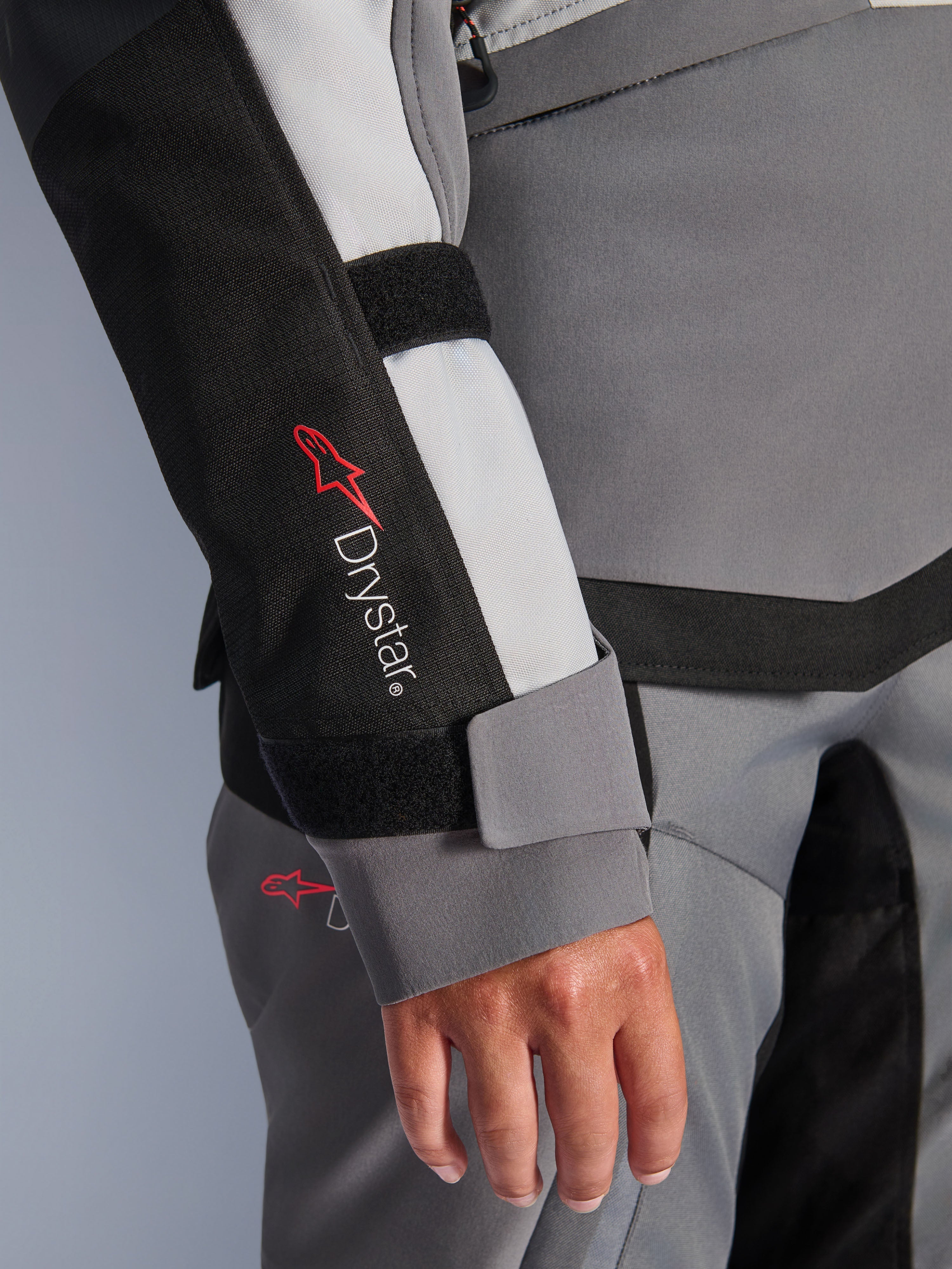 Alpinestars Stella Andes V4 Drystar mc-jacka för dam i grå textil, äventyrsmodell med ärmlogotyp och kardborre vid handleden.