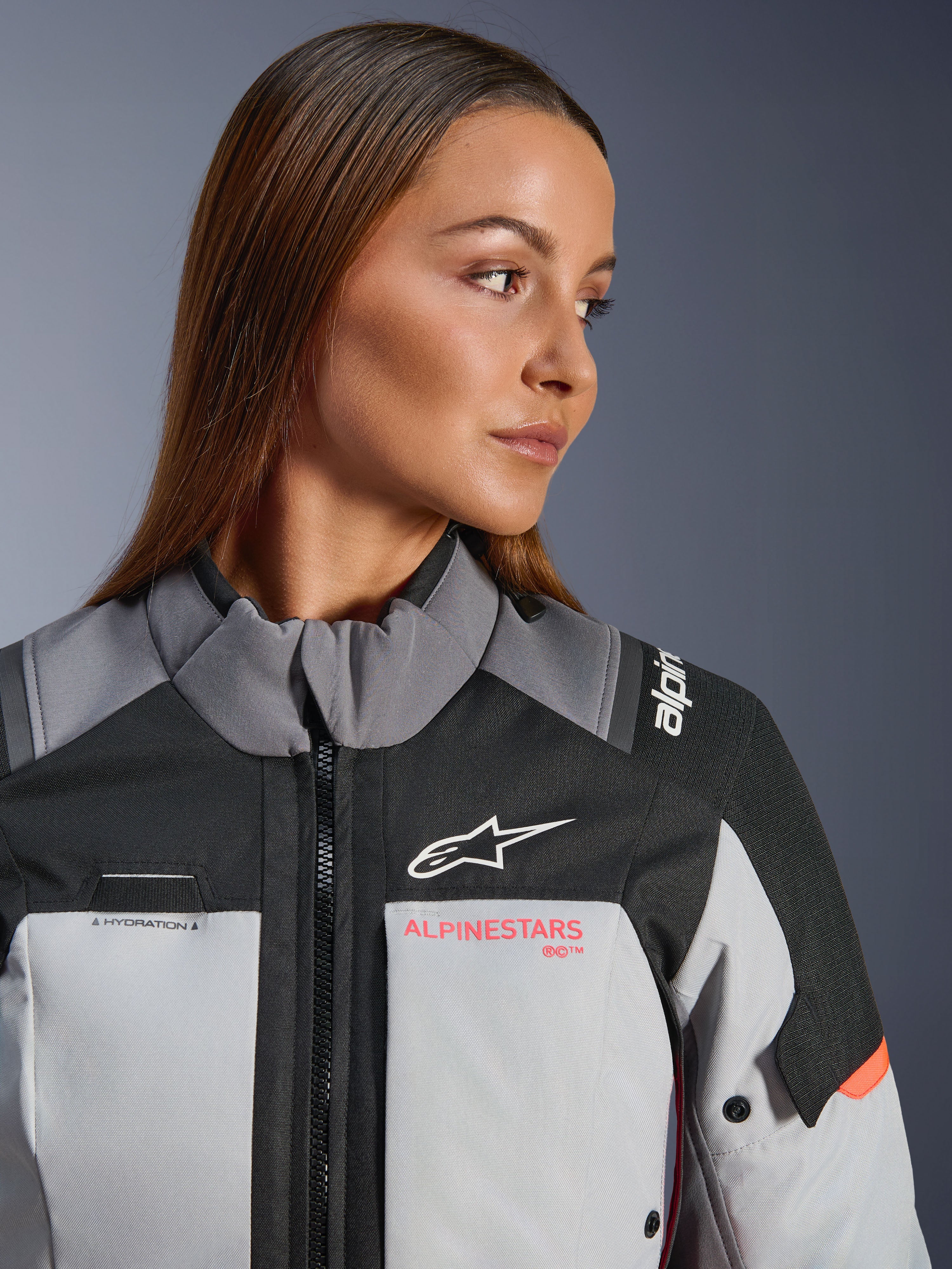 Alpinestars Stella Andes V4 Drystar® motorcykeljacka, dam, grå, svart och korallröd, vattentät textil, närbild på kvinna.