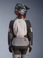 Alpinestars Stella Andes V4 Drystar jacka, vattentät MC-jacka för dam, grå och svart med coral fluo, ryggvy på modell.