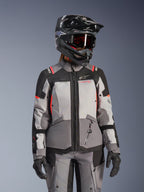 Alpinestars Stella Andes V4 Drystar damjacka, grå och svart med coral fluo, vattentät motorcykeljacka bärs av modell med hjälm.