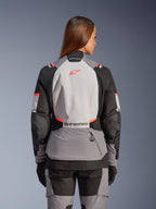 Alpinestars Stella Andes V4 Drystar® jacka, grå och korallfärgad vattentät motorcykeljacka för dam, vy bakifrån.