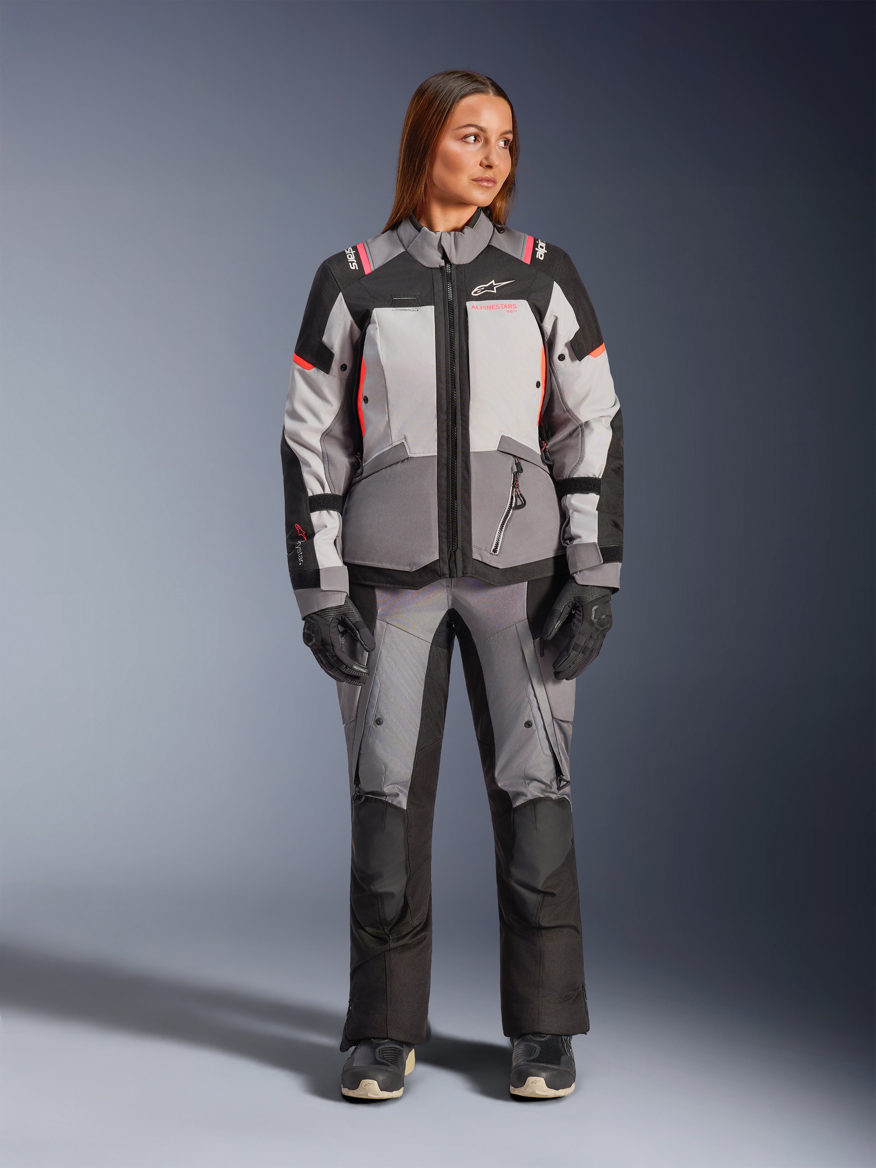 Alpinestars Stella Andes V4 Drystar® jacka, vattentät touringjacka för dam, grå och svart med korallrosa detaljer, CE-certifierat skydd bärs av modell.