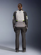 Kvinnlig förare sedd bakifrån iförd Alpinestars Stella Andes V4 Drystar®-jacka i isgrått, mörkgrått och svart med gula fluo-detaljer, utrustad med en stor bakre förvaringsficka och Alpinestars-logotyp, matchad med svarta adventure-byxor, mc-touringutrustning för alla väder