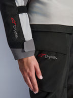 Närbild på detaljer av Alpinestars Stella Andes V4 Drystar® damjacka, ärm och matchande byxor, med Drystar-logotypen, isgrå och svart textilkonstruktion, vattentät märkning för äventyrstouring-utrustning