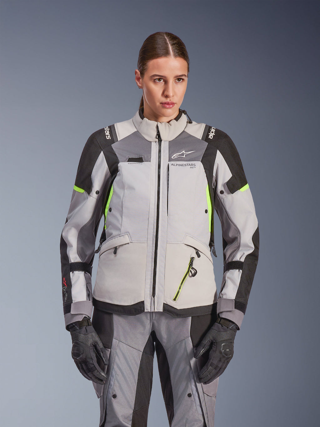 Alpinestars Stella Andes V4 Drystar® damjacka, isgrå och mörkgrå med neongula detaljer, äventyrsjacka för motorcykel, bärs med matchande byxor och handskar, med skyddande textilkonstruktion och Alpinestars-branding.