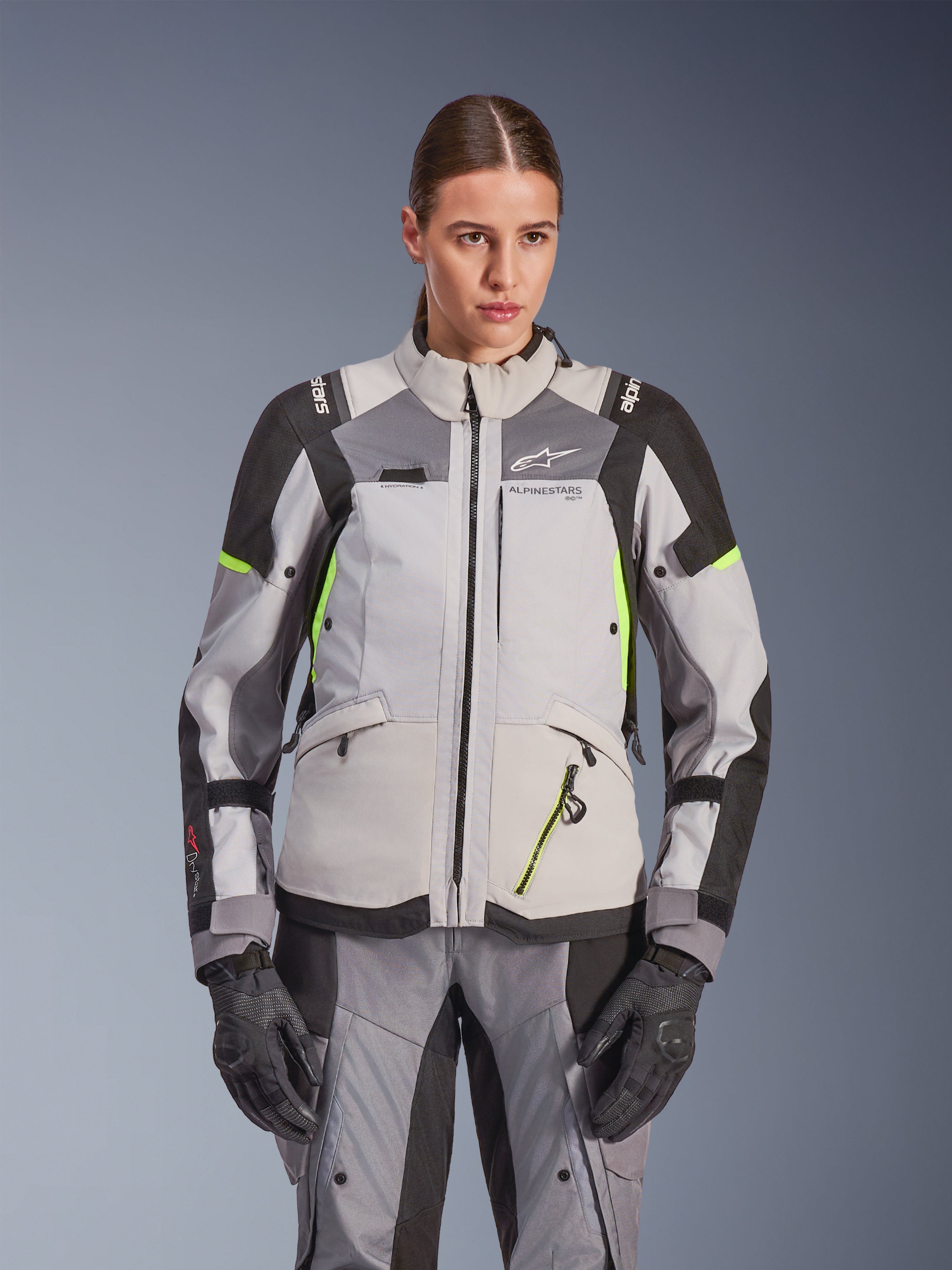 Alpinestars Stella Andes V4 Drystar® damjacka, isgrå och mörkgrå med neongula detaljer, äventyrsjacka för motorcykel, bärs med matchande byxor och handskar, med skyddande textilkonstruktion och Alpinestars-branding.