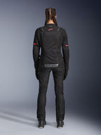 Alpinestars Stella Andes Air Drystar®-byxor, motorcykelbyxor för dam, svarta, vy bakifrån bärs med en matchande meshjacka med röda detaljer, framhäver ventilationspaneler i mesh och reflekterande logotyp på nedre delen av ryggen, designade för äventyr och landsvägstouring.