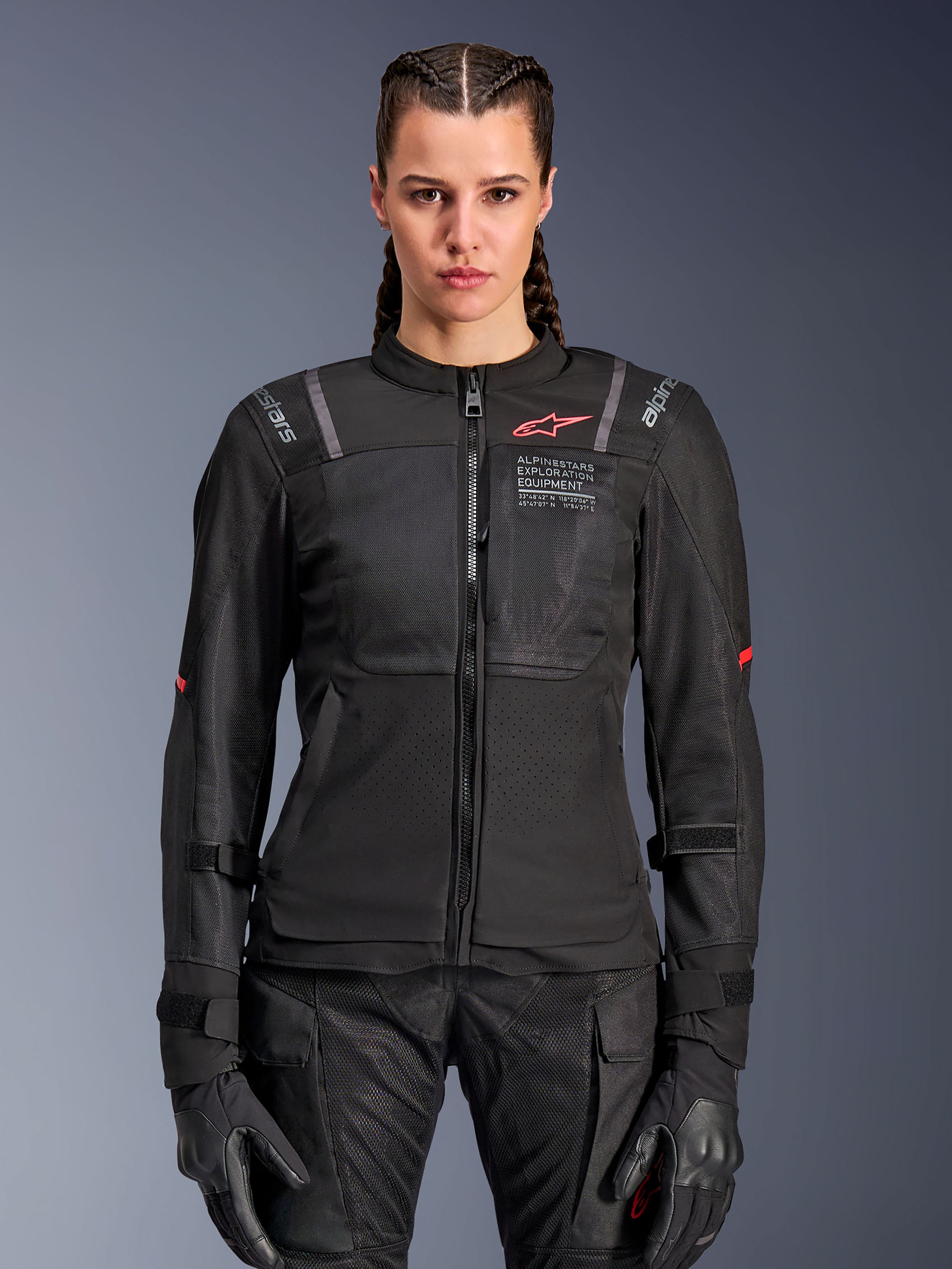 Alpinestars Stella ST-2 Air-jacka för dam, motorcykeljacka, svart, framifrån på modell, med meshpaneler, röd logotyp på bröstet och Alpinestars Exploration Equipment-märkning, bärs med svarta handskar och MC-byxor