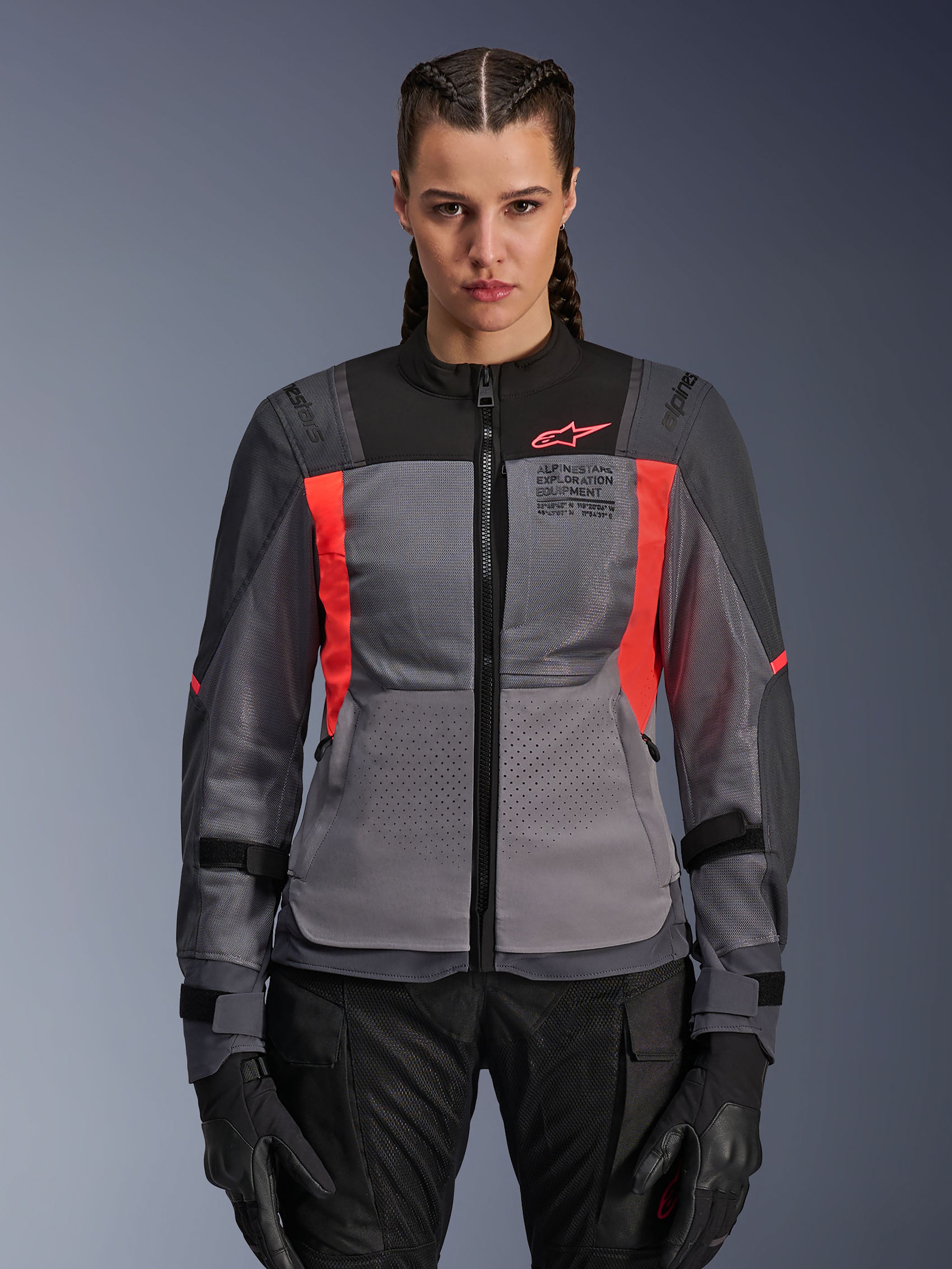 Alpinestars Stella ST-2 Air-jacka, motorcykeljacka för dam, mörkgrå och neonkorall, modell som bär ventilerad textiljacka med meshpaneler, ljusa korallfärgade accenter och logotyp på bröstet, modern äventyrsstil