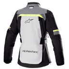 Alpinestars Stella Bogota' Pro Drystar®-jacka för dam, baksida, isgrå och mörkgrå med fluorescerande gula detaljer, har en stor logotyp på ryggen, texten 'Tech Touring', vertikala ventilationsdragkedjor och förstärkta dragspelspaneler på armbågarna.
