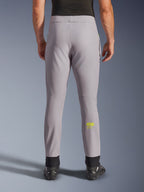 Alpinestars Aeroshell Pants, motorcykelbyxor, mellangrå och neon gul, vy bakifrån som visar gul Astars-logotyp på vaden, svarta elastiska ankelmuddar, modern softshell-textildesign för landsvägs- och vardagskörning.