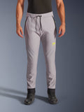 Alpinestars Aeroshell Pants, mellangrå och neongula, crossover softshell-motorcykelbyxor med svart dragsko i midjan och åtsittande benslut, gul logotyp på vänster lår, förböjda knän, sportig jogger-silhuett