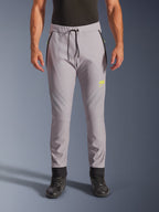 Alpinestars Aeroshell Pants, mellangrå och neongula, crossover softshell-motorcykelbyxor med svart dragsko i midjan och åtsittande benslut, gul logotyp på vänster lår, förböjda knän, sportig jogger-silhuett