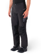Alpinestars Hyde XT Drystar® Pants, Adventure Touring Motorcycle Pants, Black, worn with black boots, featuring laminated Drystar®XF membrane branding, reinforced knee panels, and zippered cargo pockets.