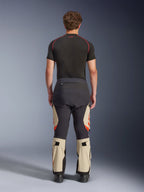 Alpinestars Halo Pro Drystar® XF laminerade byxor, Mastic Black, sedda bakifrån på en modell, svart och beige färgblockering med orangea logotyper, äventyrsbyxor för motorcykel med hållbar textilkonstruktion och justerbara vadsektioner