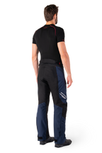Alpinestars St-1 Waterproof Pants, Adventure Touring Pants, Dark Blue Black and Bright Red, rear side view worn with a black short-sleeved base layer and black riding boots, featuring a streamlined design with reflective branding and red accents