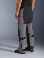 Alpinestars Andes Pro Drystar® XF byxor, äventyrsmotorcykelbyxor, mörkgrå och svarta, trekvartsvy bakifrån, textilkonstruktion med svart förstärkt säte och paneler på innerbenen, dragkedjor vid bensluten och justerbara flikar
