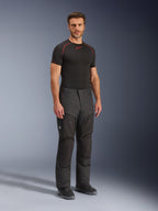 Alpinestars Cusco Drystar® Pants, svarta mc-byxor i textil, bärs av en modell med svart baslager och stövlar, med ripstop-tyg, stora cargofickor med 'Terra'-logotyp och ergonomisk design för äventyrskörning.
