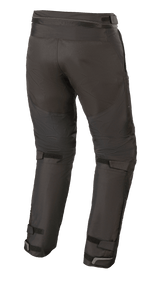 Alpinestars Raider V2 Drystar® byxor, textilbyxor för motorcykel, svarta, vy bakifrån som visar dragkedja i midjan för sammankoppling samt justerbara kardborreband på baksidan av benen och vid anklarna.