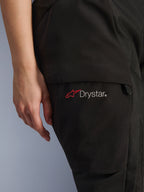Alpinestars Stella Andes V4 Drystar® dambyxor, äventyrsmotorcykelbyxor, svarta, närbild på lårområdet med Drystar-logotyp och röd stjärnikon, slitstarkt textilmaterial med cargoficka och dragkedjedetalj