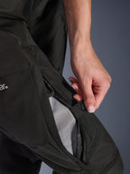 Alpinestars Stella Andes V4 Drystar®-byxor för dam, motorcykelbyxor, svarta, närbild på en hand som öppnar lårventilationen med dragkedja för att visa meshfoder för luftflöde, slitstark textil äventyrsutrustning