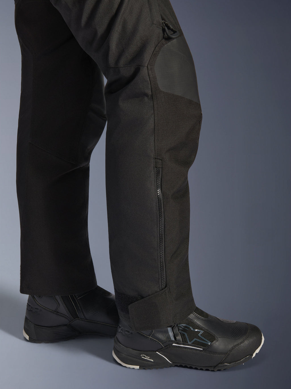 Alpinestars Stella Andes V4 Drystar® byxor, motorcykelbyxor för dam, svarta, närbild på underbenet med sidodragkedja och justerbart benslut, bärs med svarta Alpinestars MC-stövlar
