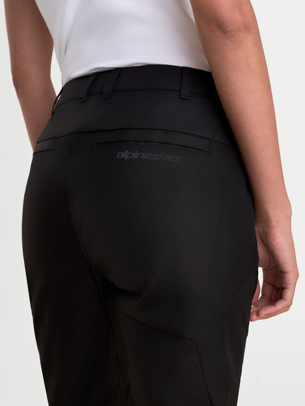 Alpinestars Stella C-1 Waterproof Pants, women's urban contemporary motorcycle riding pants in black, rear close-up view showing belt loops, overlap-construction rear pockets, and tonal Alpinestars branding