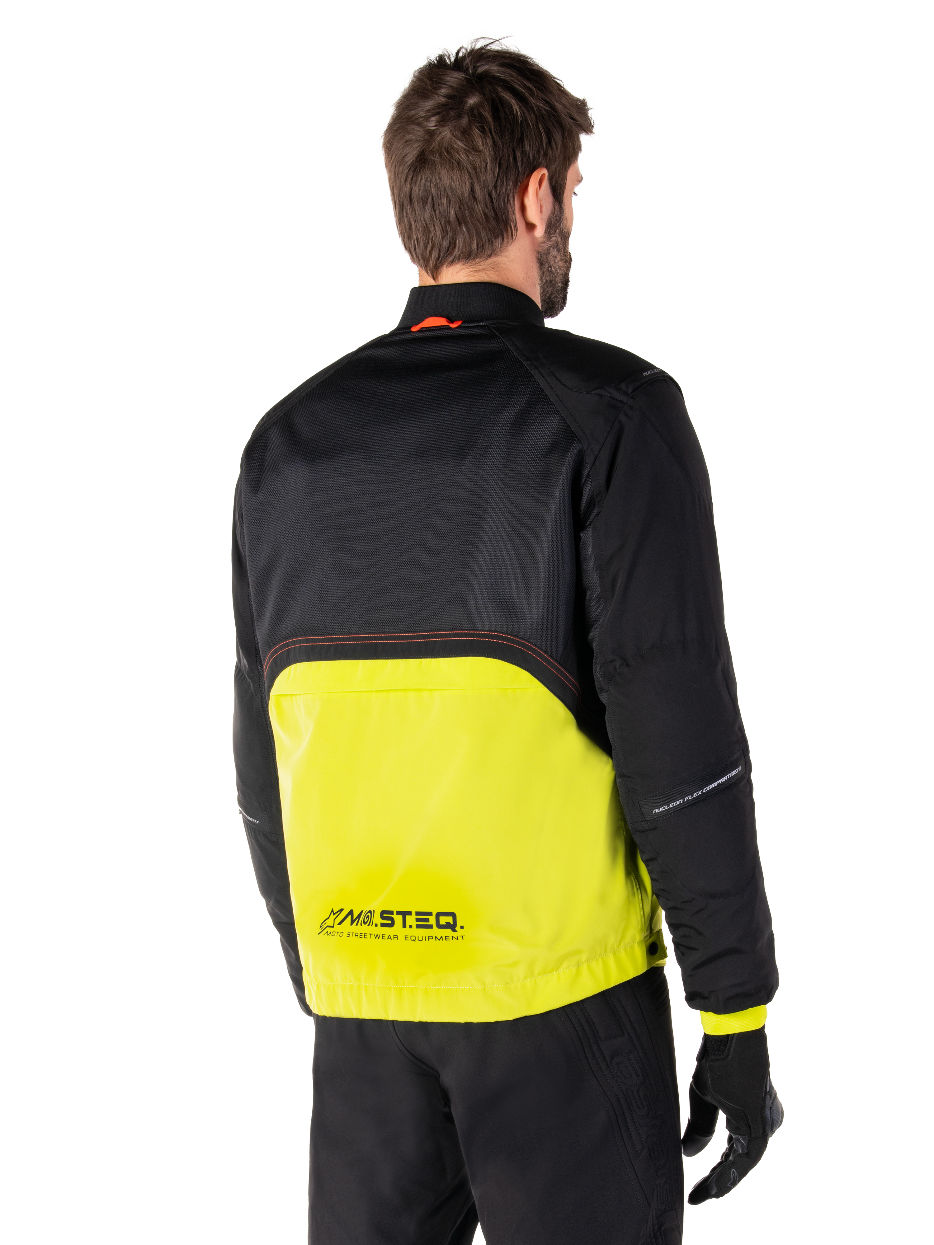 Alpinestars Mootant Waterproof Parka, Motorcycle Jacket, Lime Punch and Black, back view showing black upper mesh and bright lime green lower section, featuring MO.ST.EQ. branding, worn with black riding pants and gloves