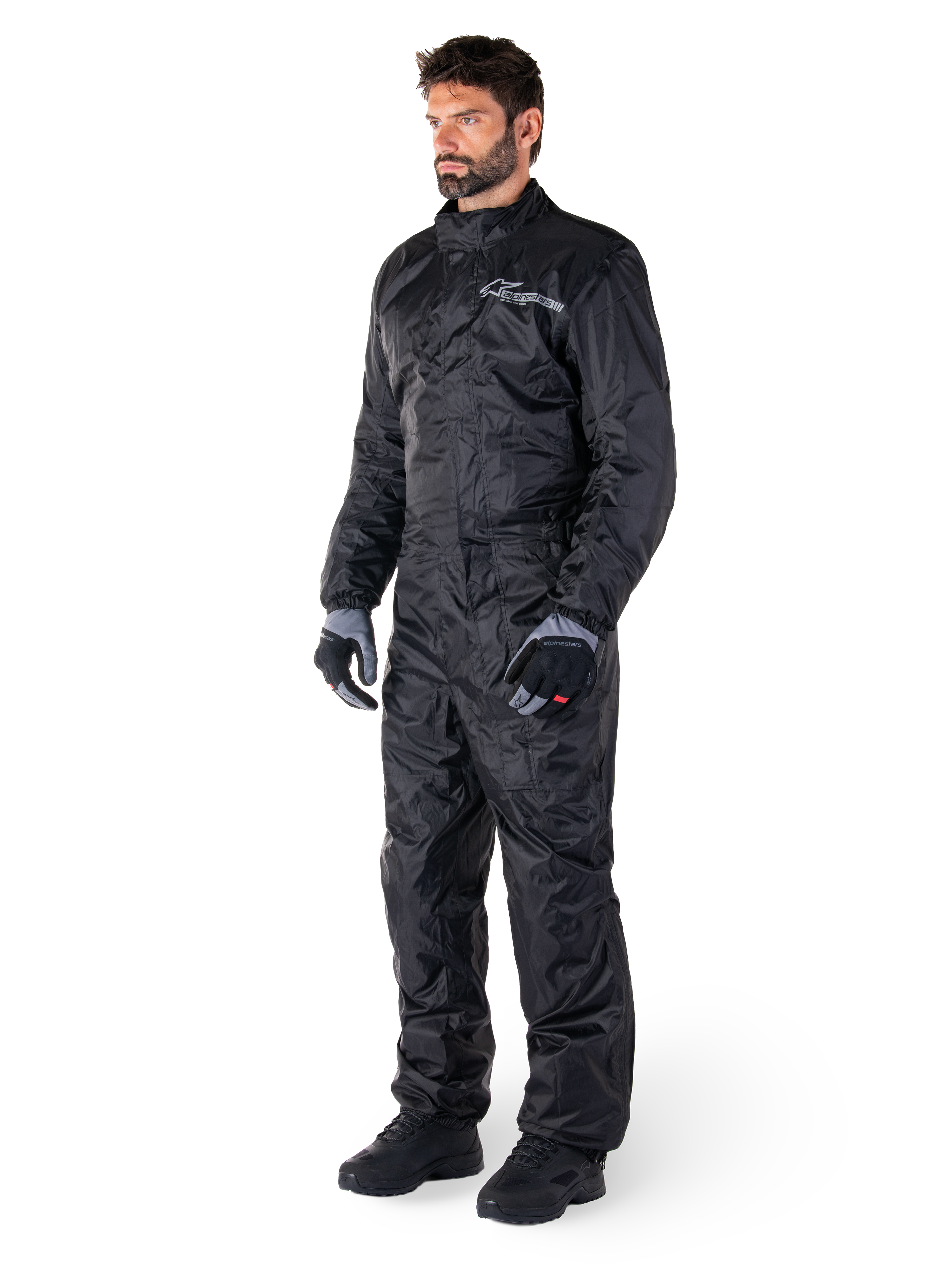 Alpinestars Hurricane Rain V2-regnställ, svart, vattentät motorcykeloverall i ett stycke, bärs med handskar och stövlar, reflekterande Alpinestars-logotyp på bröstet, lättviktsdesign för skydd i vått väder