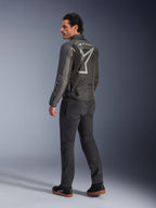 Alpinestars Axton Jacket, Men's Motorcycle Jacket, Black and Anthracite, back view featuring a large grey wrap-around logo and accordion shoulder panels, worn with dark riding pants and black sneakers, urban contemporary style with racing heritage.