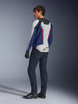 Alpinestars AST V3 Air-jacka, mc-jacka i silver, mörkblått och klarrött, vy bakifrån bärs med mörkblå mc-jeans och svart utrustning, med ventilerande meshpaneler och Alpinestars-logotyp på ryggen, teknisk mc-utrustning med sportpassform.